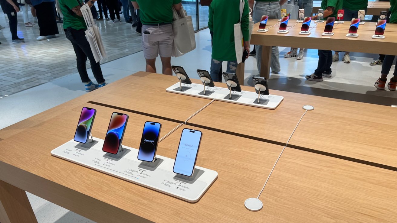 Деревянные столы-витрины в окружении сотрудников Apple