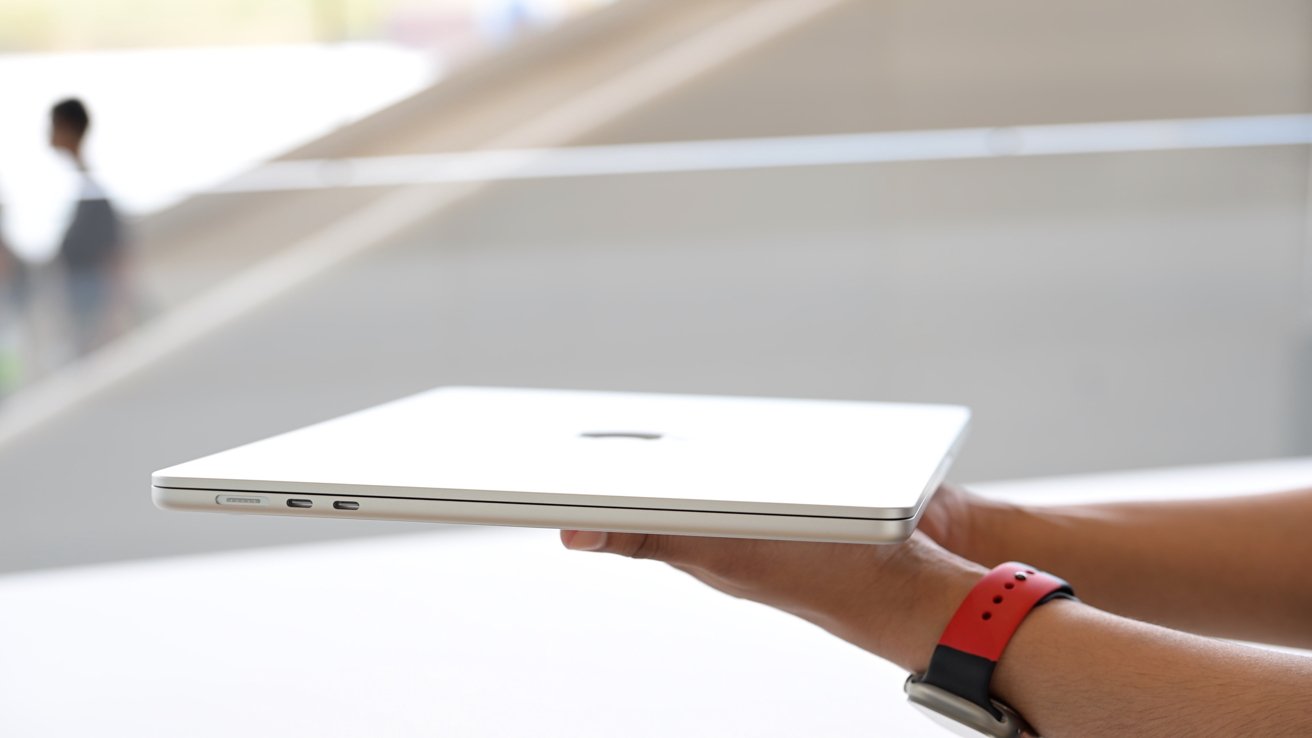 Держит новый 15-дюймовый MacBook Air