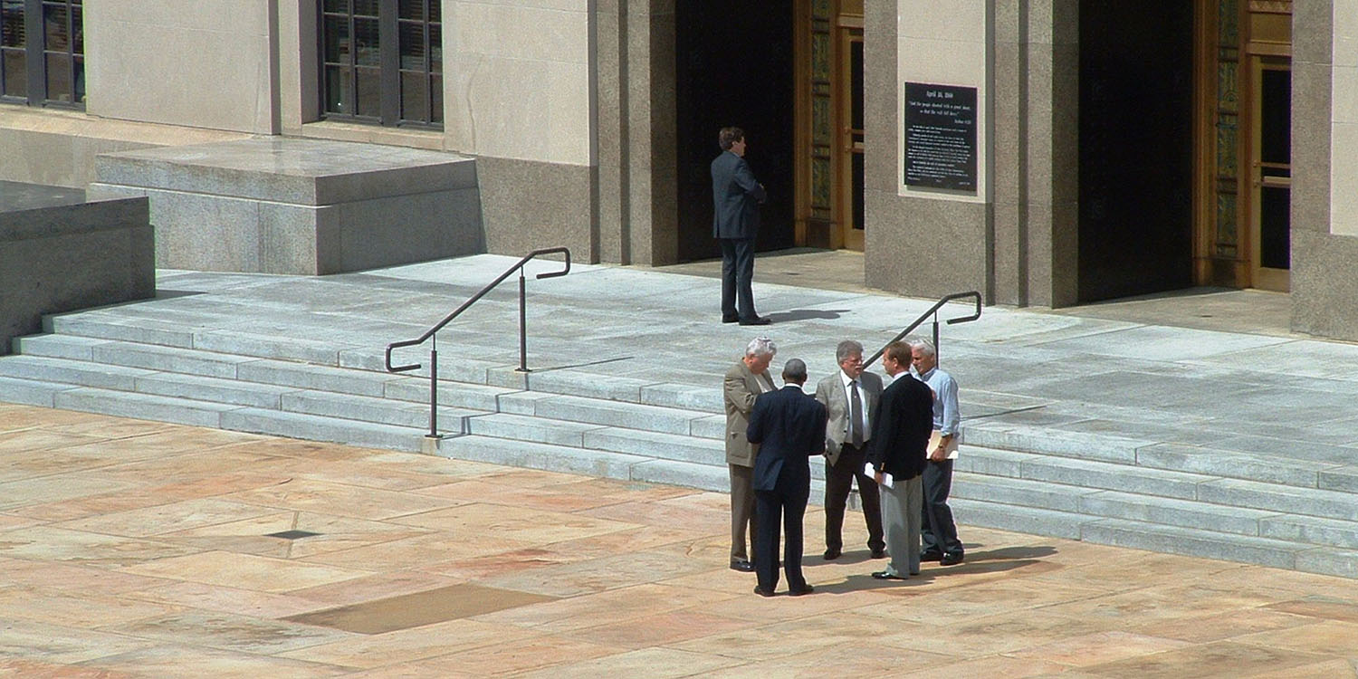 Qualcomm преследует Apple |  Сток-фото мужчин на ступенях здания