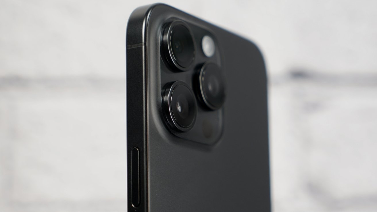 iPhone 15 Pro Max на фоне белого кирпича