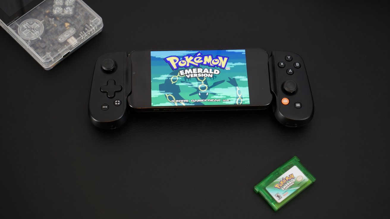 iPhone в ручке контроллера с надписью «Pokemon Emerald» на экране
