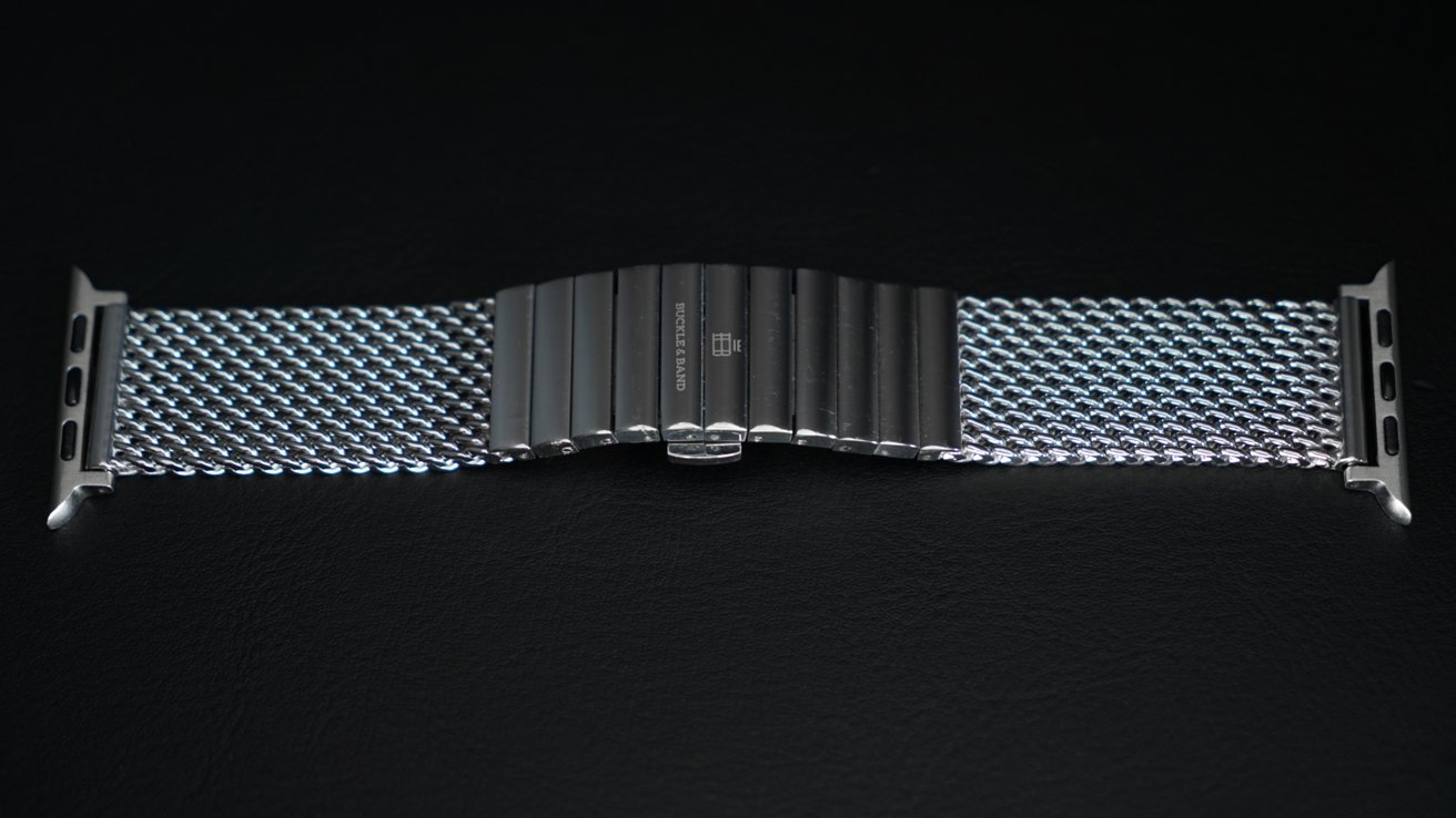 Миланский ремешок из нержавеющей стали для Apple Watch, лежащий на столе.