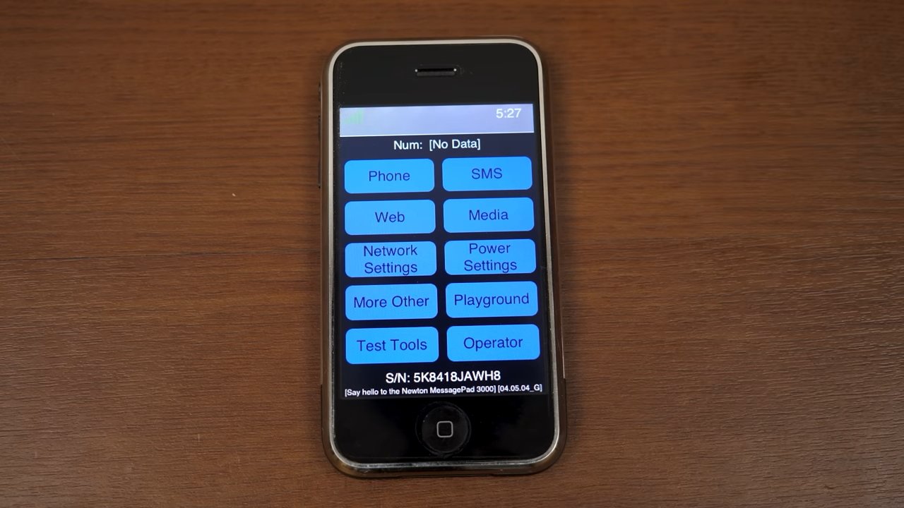 Смартфон с меню с такими опциями, как «Телефон», «СМС», «Интернет» и «Медиа» на деревянной поверхности.