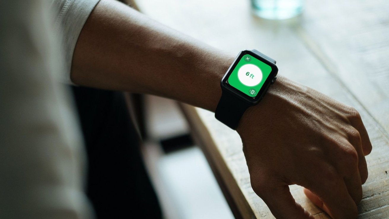 На запястье человека с Apple Watch на экране отображается цифра «6 футов», что указывает на необходимость социального дистанцирования.