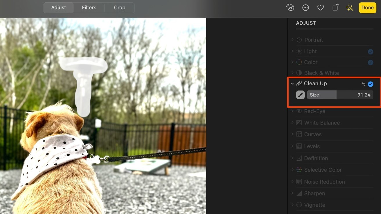Собака с банданой в горошек на поводке, стоящая на гравии возле забора, с размытым внешним фоном и показанным меню редактирования.
